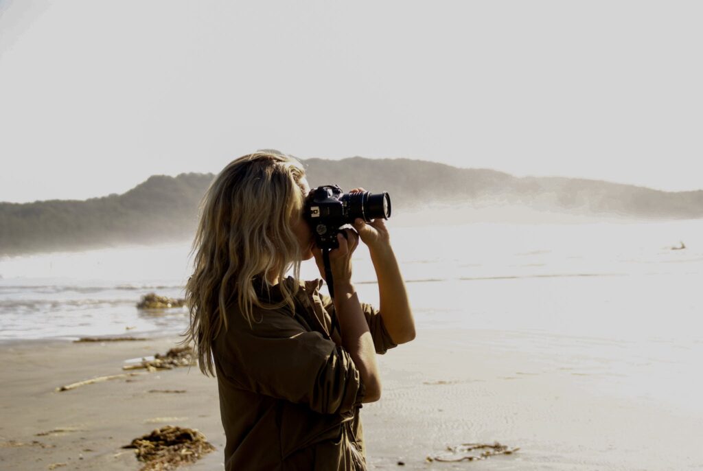 Woman Holding A Black Dslr Camera And Taking Pictures